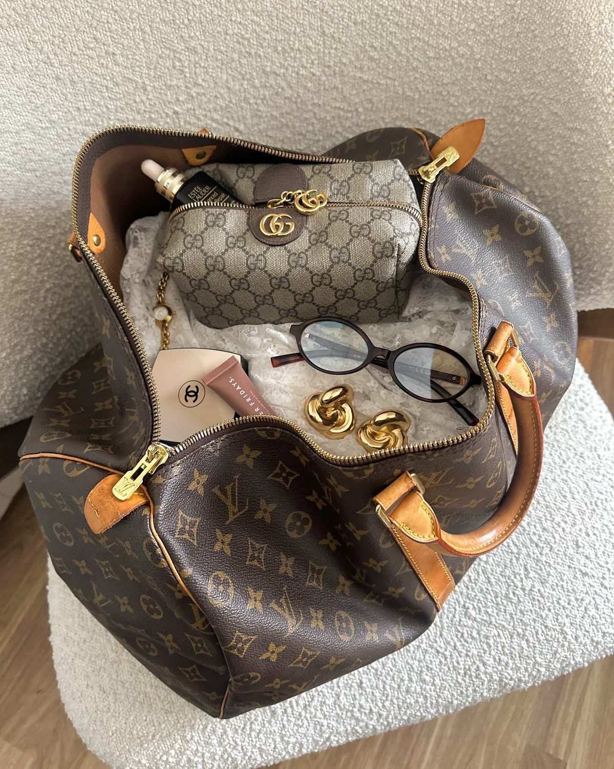 Sac de voyage Keepall Louis Vuitton en toile monogramme ouvert, garni d'une pochette et d'accessoires de voyage
